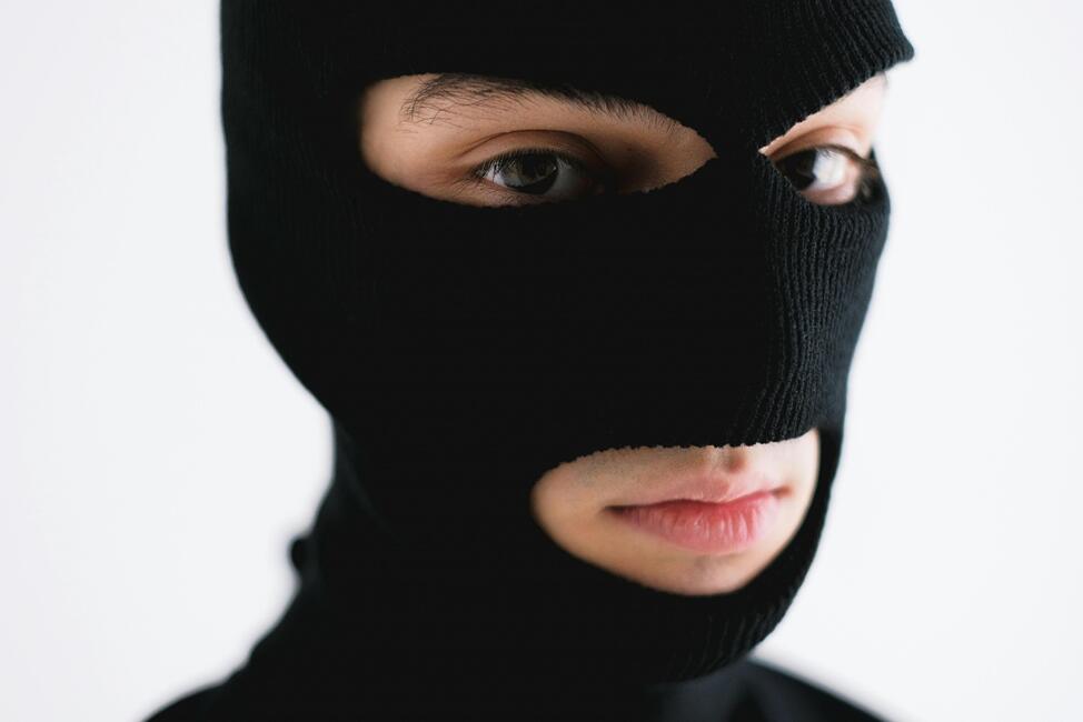 Person wearing a black ski mask, with only their eyes and mouth visible.