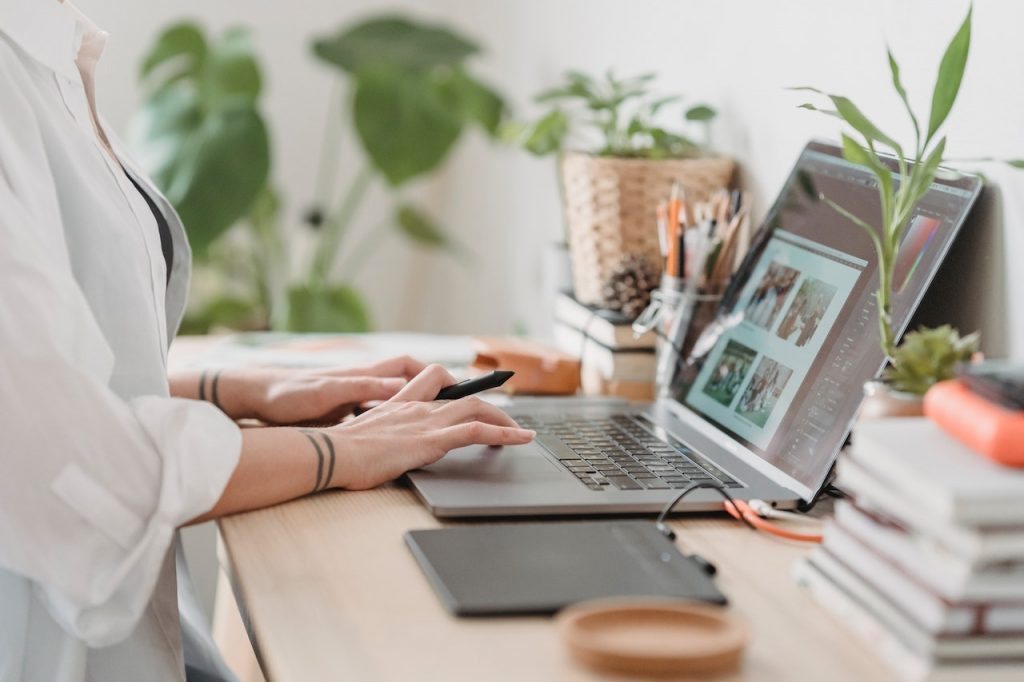 A woman sitting at the desk and typing on a laptop